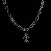 a silver chain necklace with a cross on it