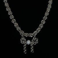 a silver necklace with a pearl on it