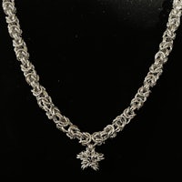 a silver chain necklace with a snowflake pendant