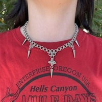 a woman wearing a necklace with spikes on it