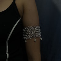 a woman with a chain bracelet on her arm